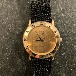 Vintage Gucci Gold Face Watch with Roman Numerals and Black Band